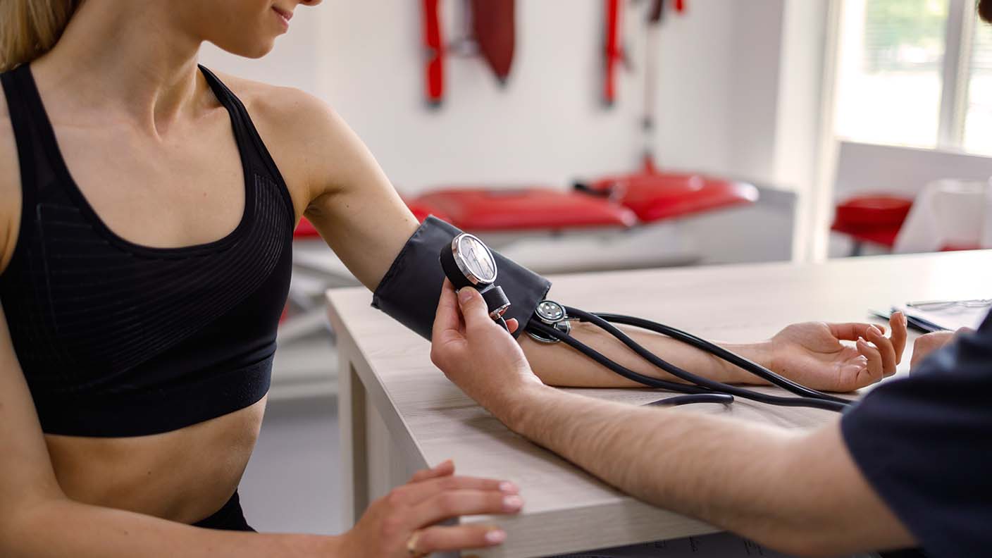 Médico tomando tensión a una mujer