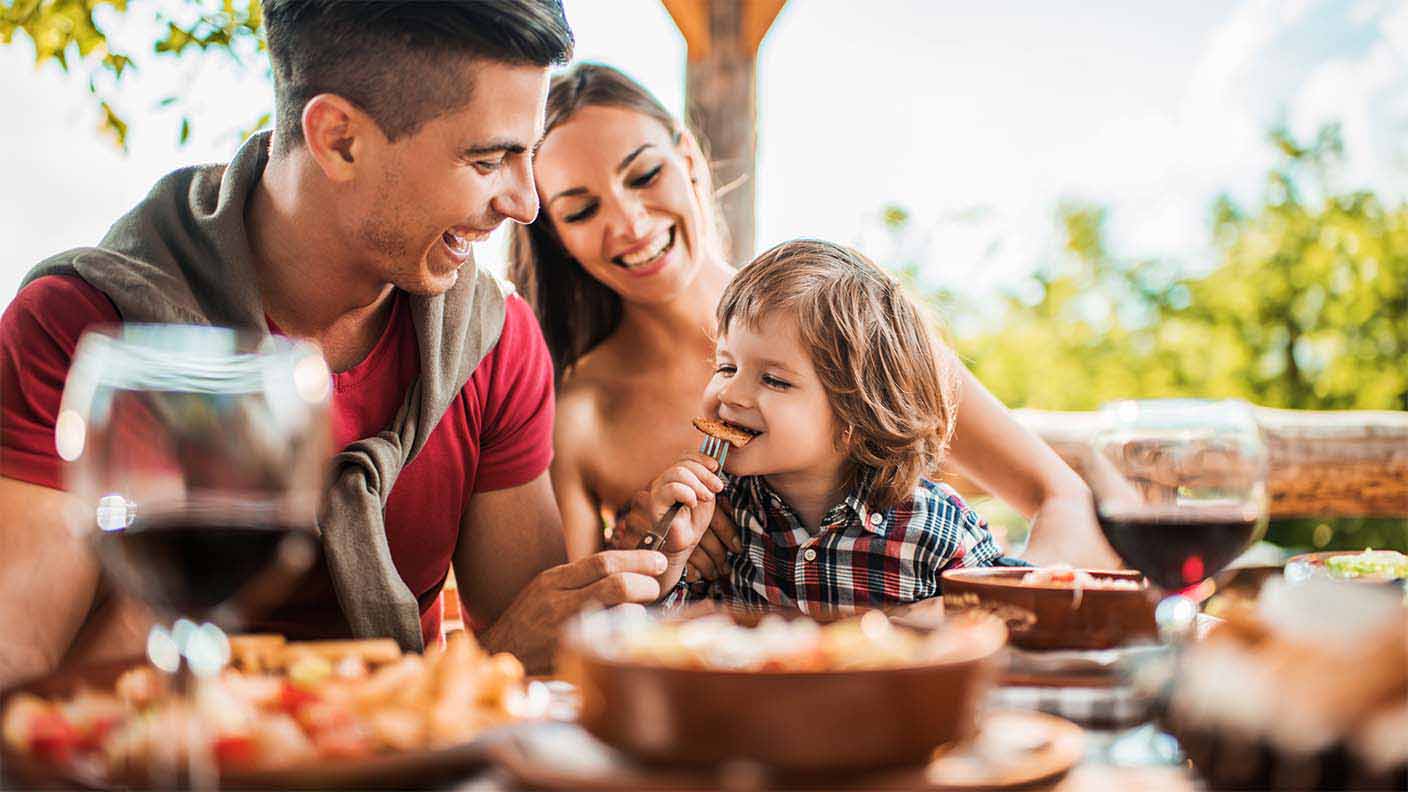 Padre y madre comiendo con su hijo