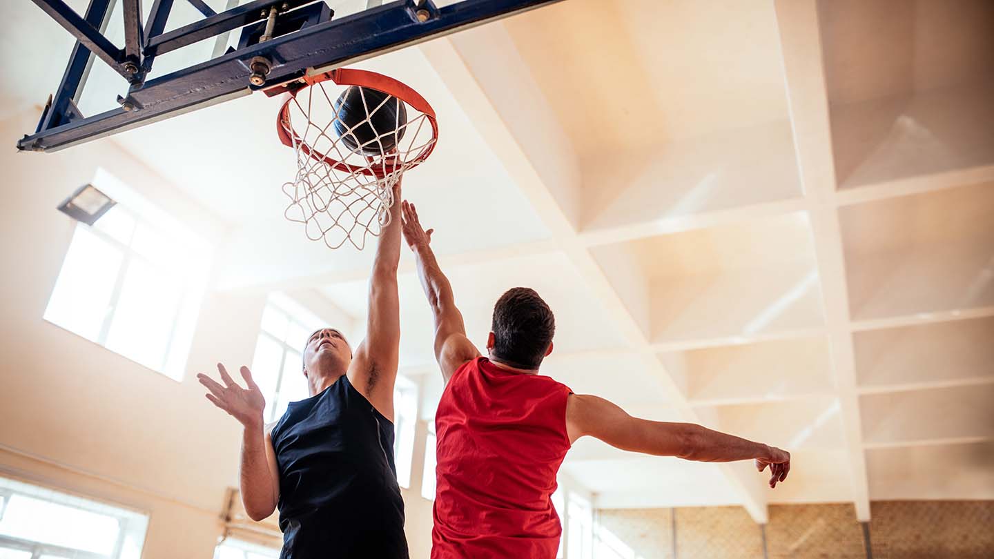 Dos hombres jugando al baloncesto