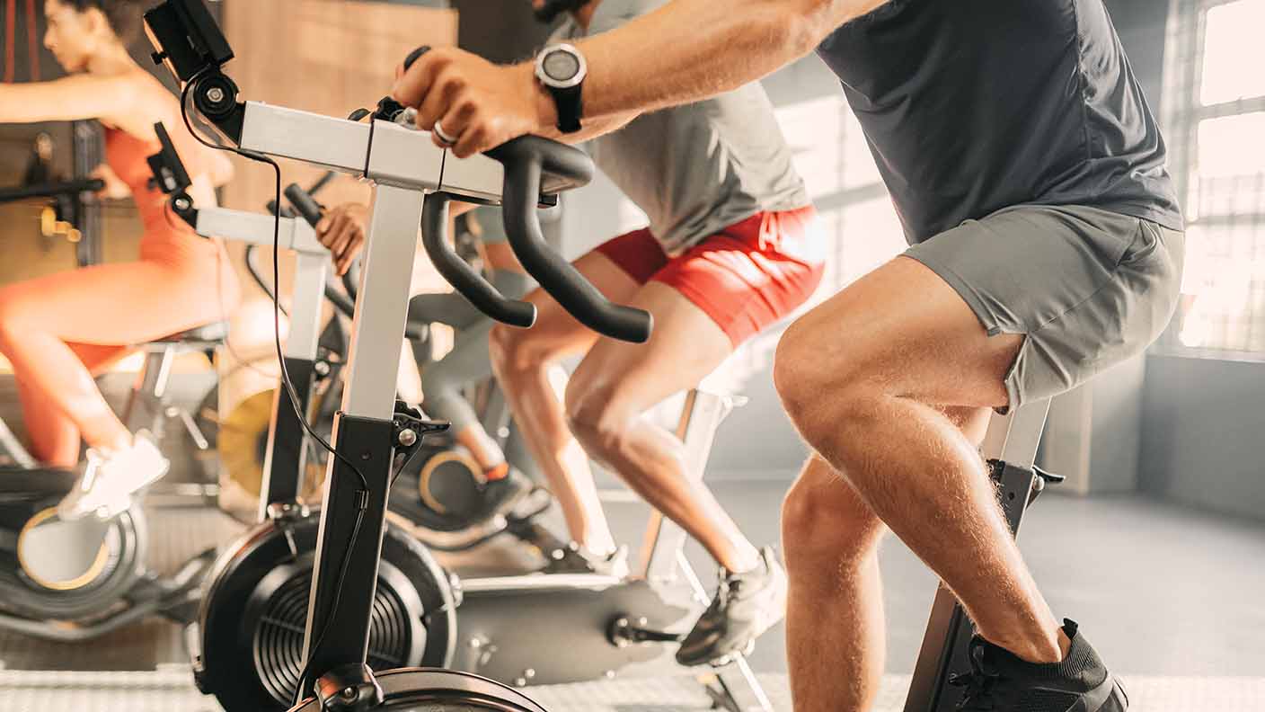 4 personas haciendo bici estática en el gimnasio