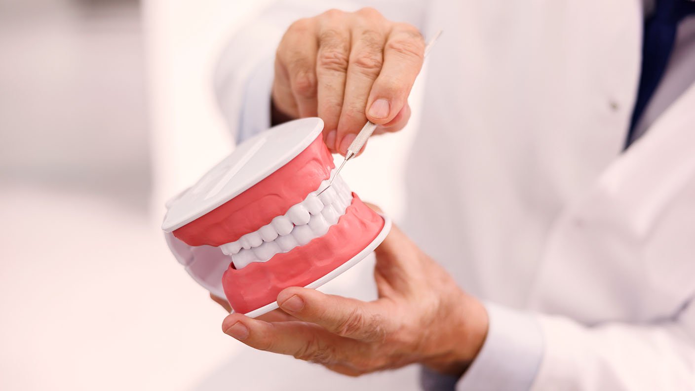 Dentista con dentadura en las manos