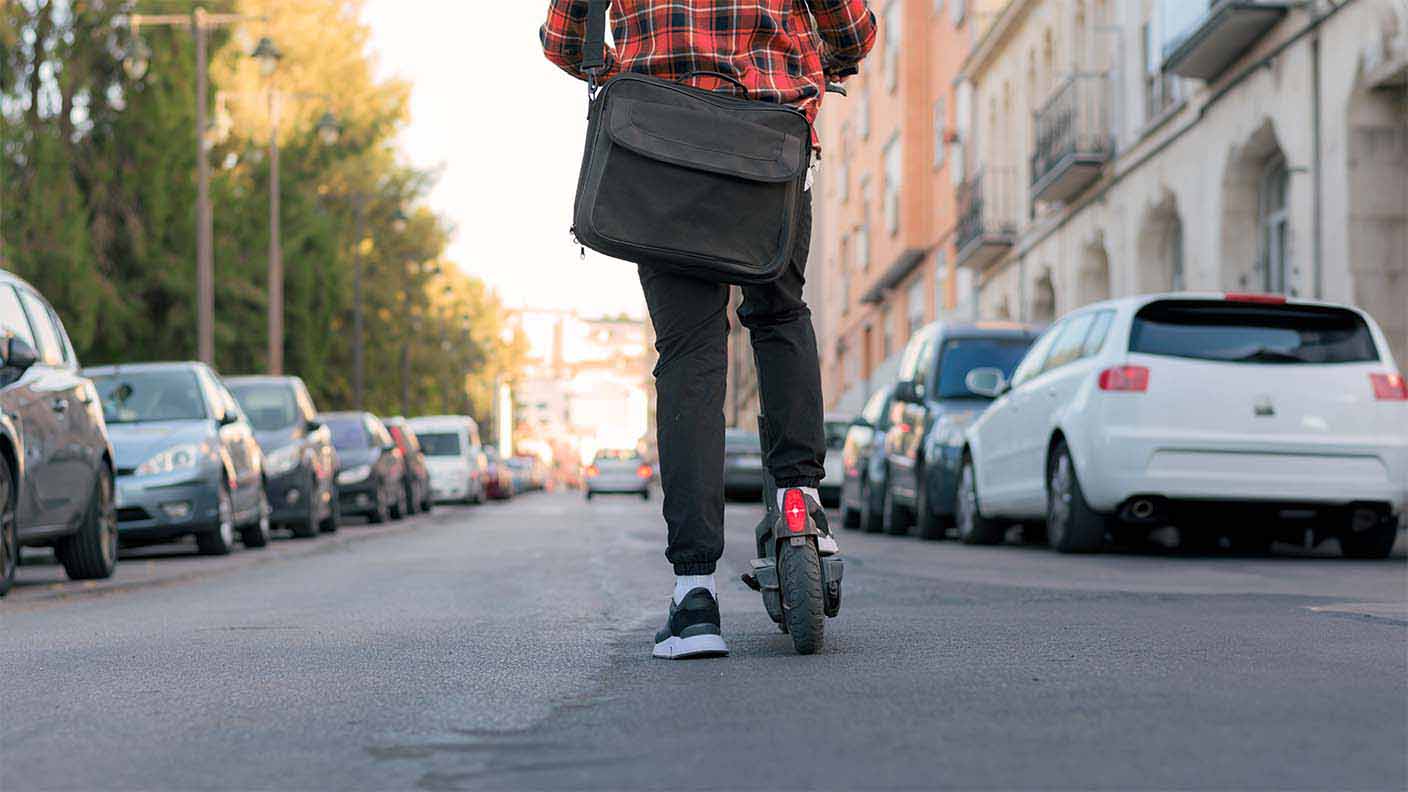 Hombre en carretera con patinete eléctrico